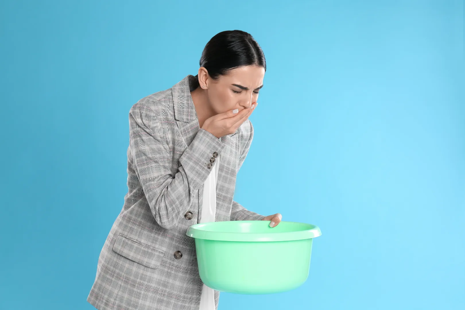 Woman feeling Vomiting and holding a basin due to common side effects of compounded semaglutide